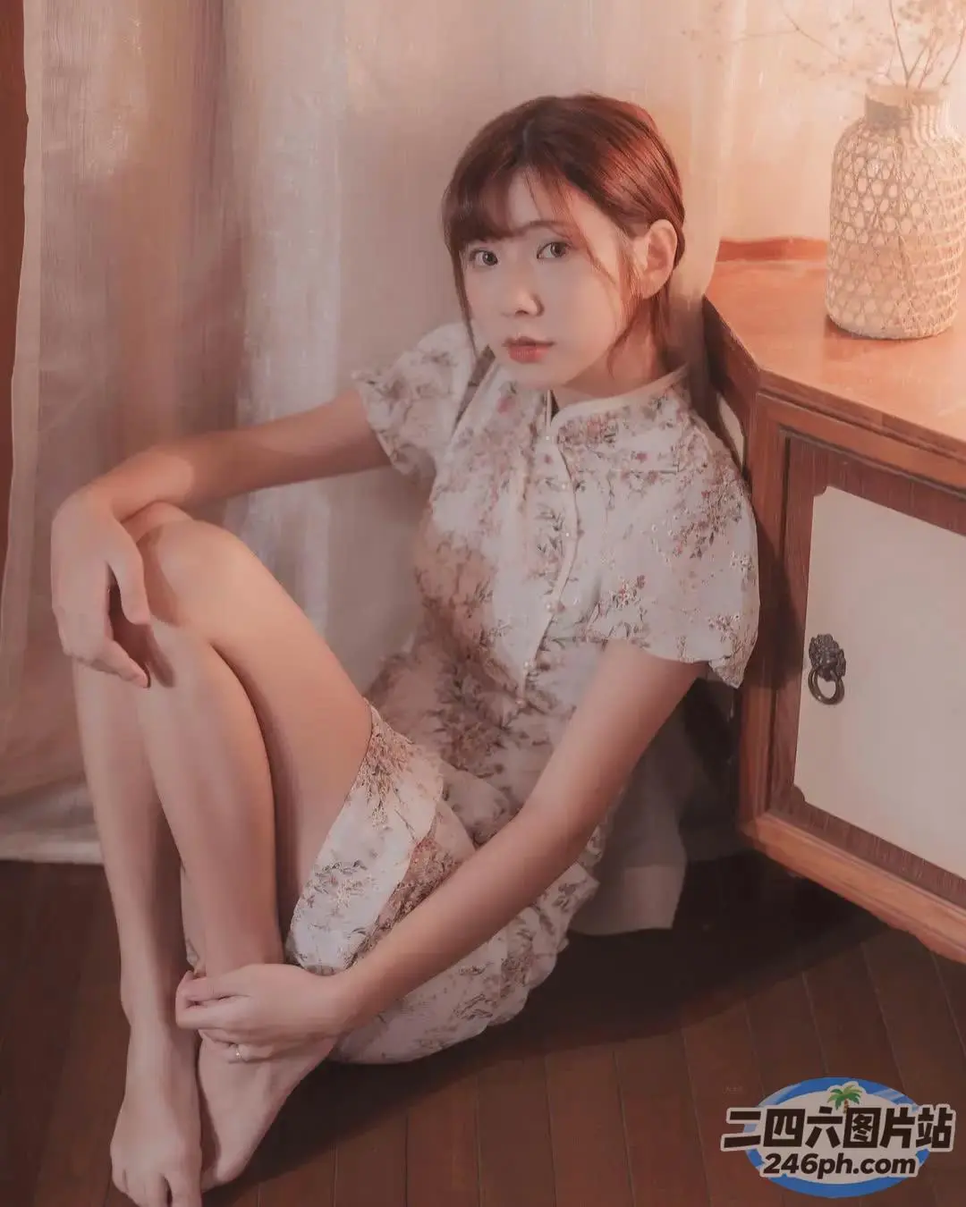 穿着白色连衣裙坐在地板上的 arafed 女人