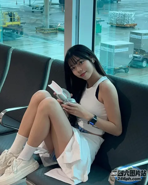 阿拉菲坐在机场的长椅上看书