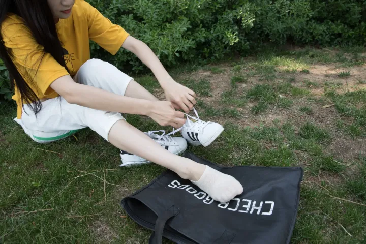 阿拉菲坐在地上系一双鞋带