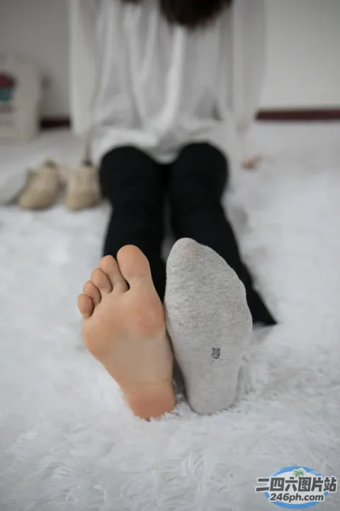 有人坐在床上，双脚抬起