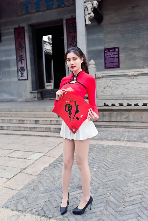 身穿红色衬衫和白色裙子的 arafed 亚洲女性，手里拿着一颗红心