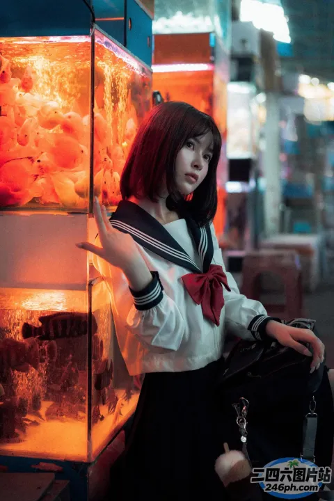 有一个女人坐在鱼缸旁边的地上