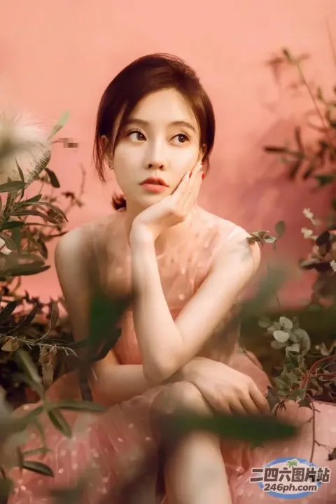 一个女人坐在粉红色背景的花园里