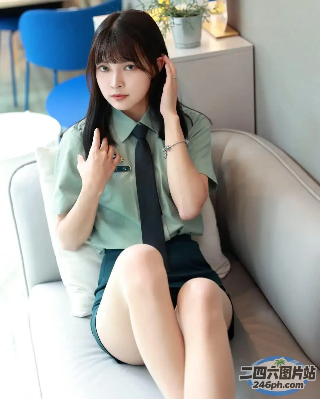 有一个女人坐在沙发上，打着领带