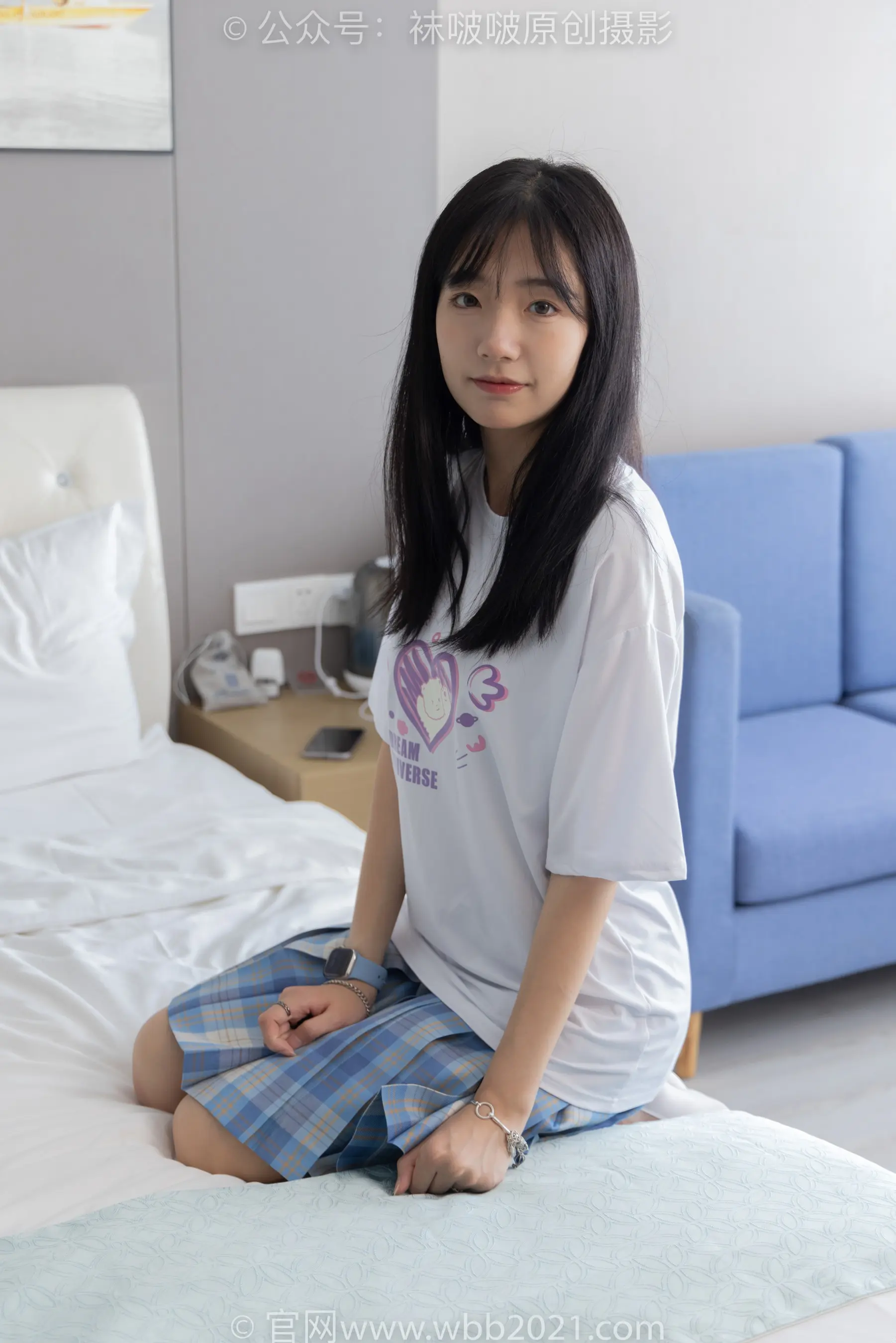 坐在酒店房间床上的阿拉菲德亚裔妇女
