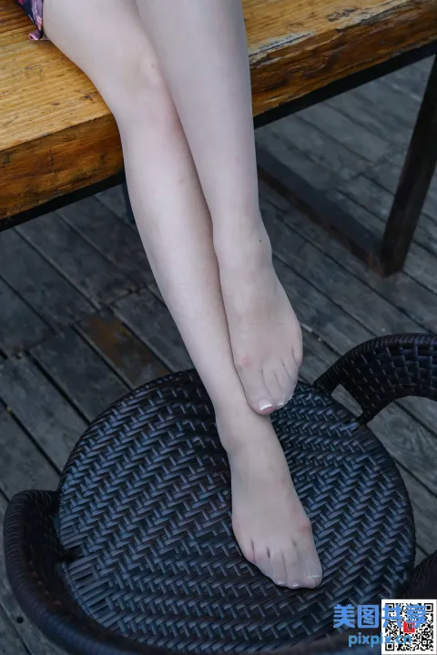 有个女人坐在椅子上，脚放在桌子上