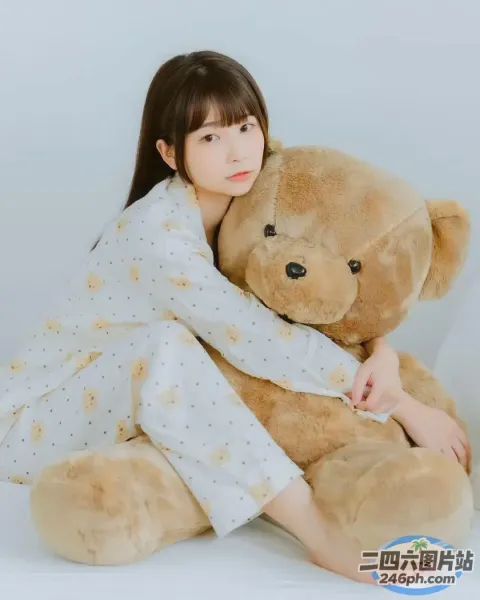 阿拉菲德女孩和一只大泰迪熊坐在地板上