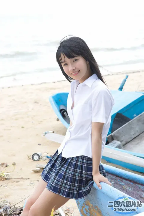 身穿校服的 arafed 亚洲女孩在海滩上摆姿势