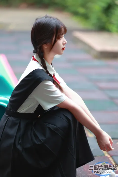 有个女人坐在长凳上，手里拿着一本书