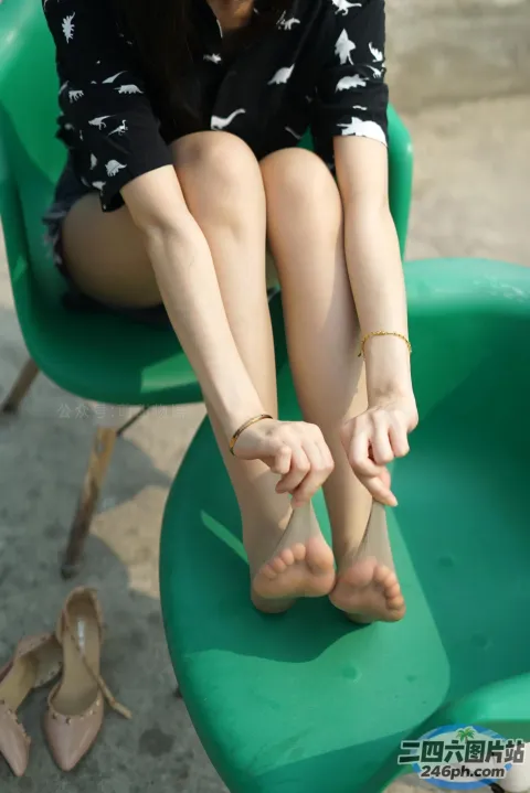 阿拉菲德女人坐在绿色椅子上，双叉