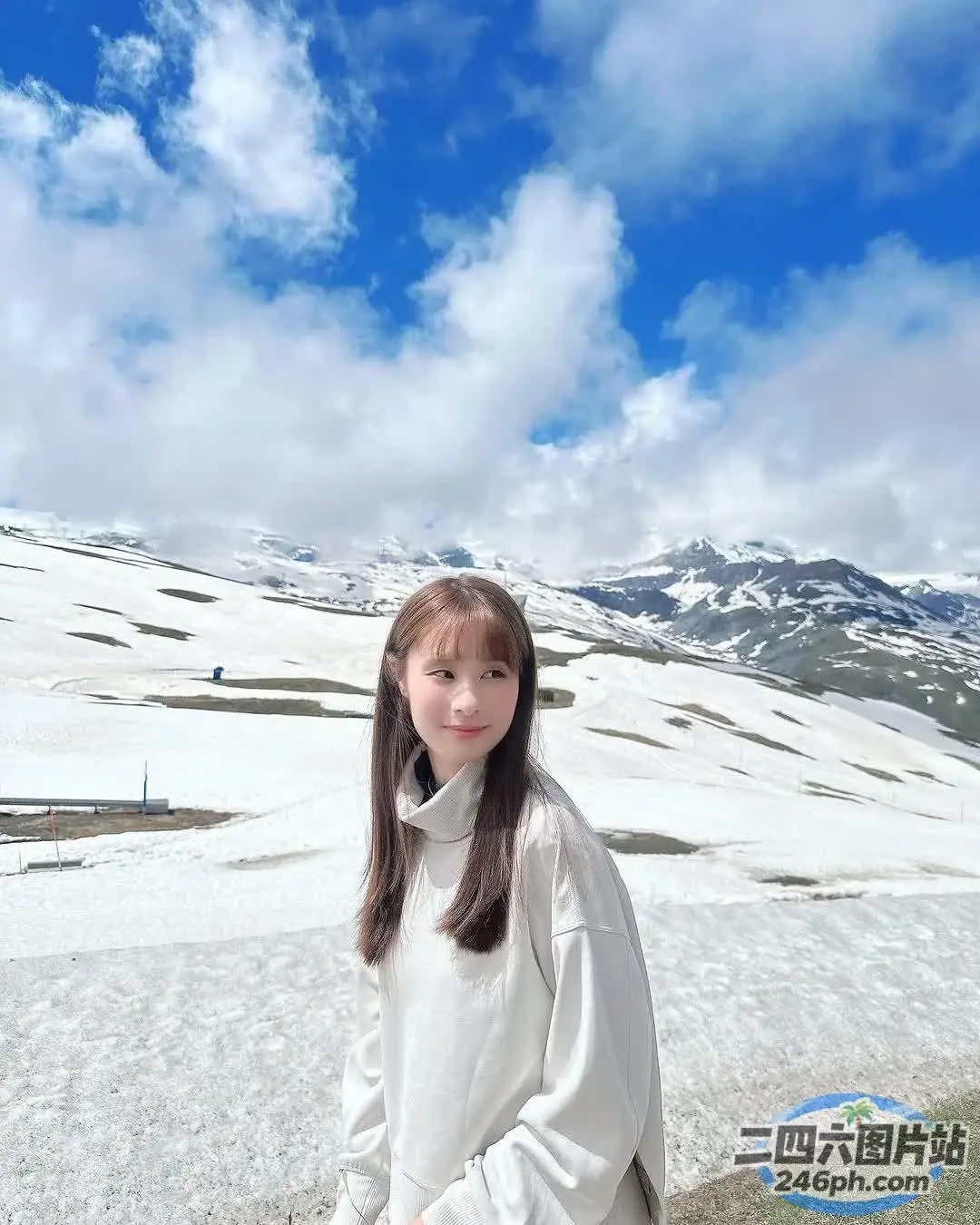 有个女人拿着滑雪板站在雪地里