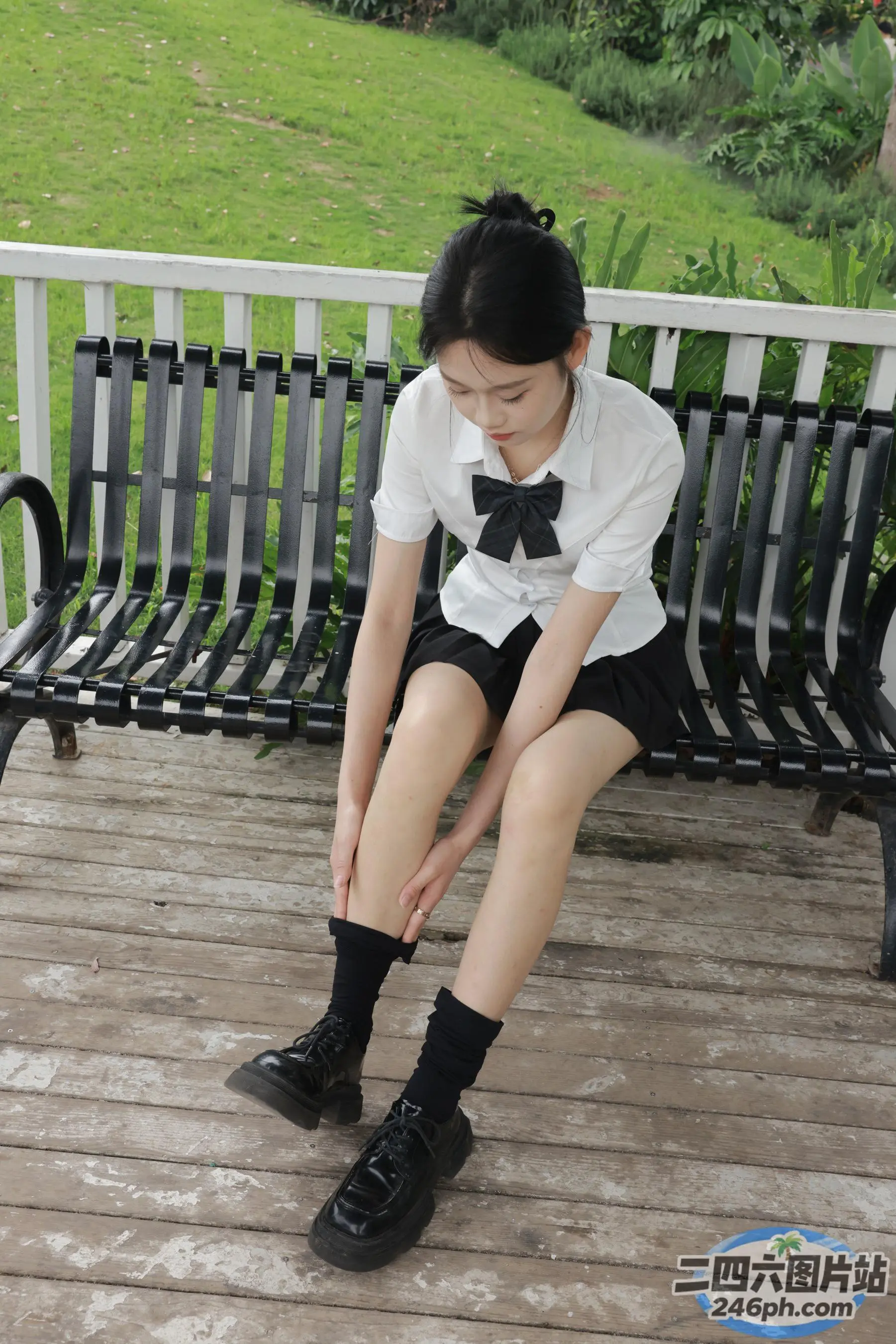有一位年轻女子坐在长凳上，双腿交叉