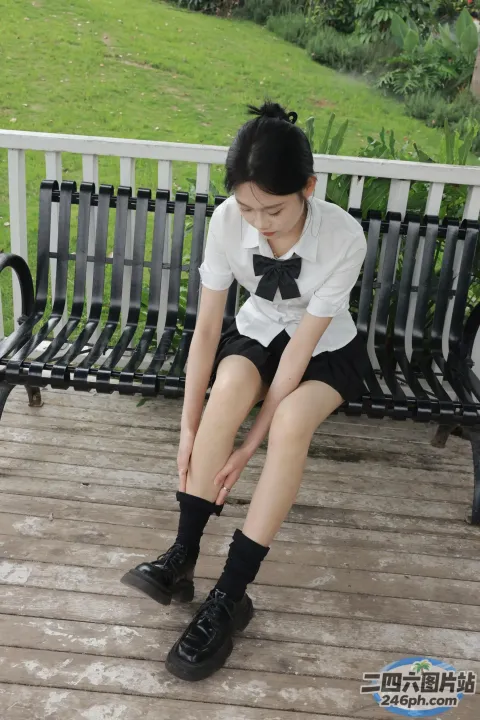 有一位年轻女子坐在长凳上，双腿交叉