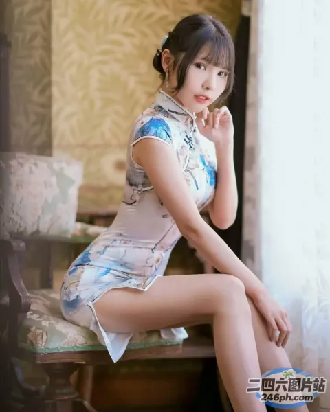 坐在椅子上穿着旗袍的 arafed 亚洲女性