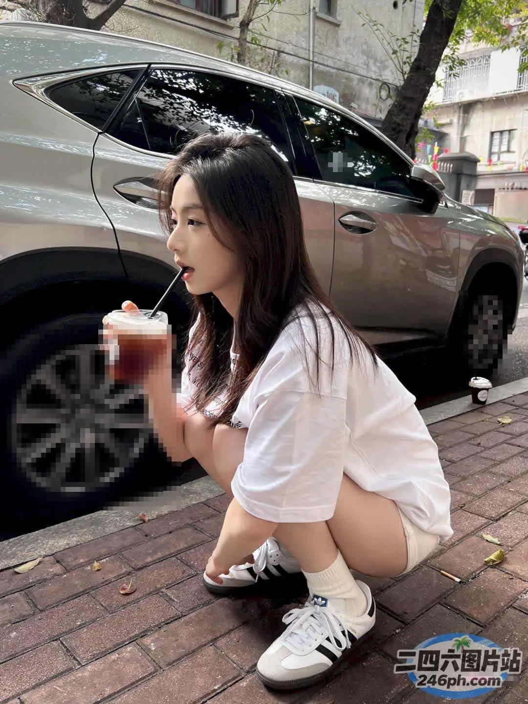 坐在人行道上喝酒的 Araffe 女孩