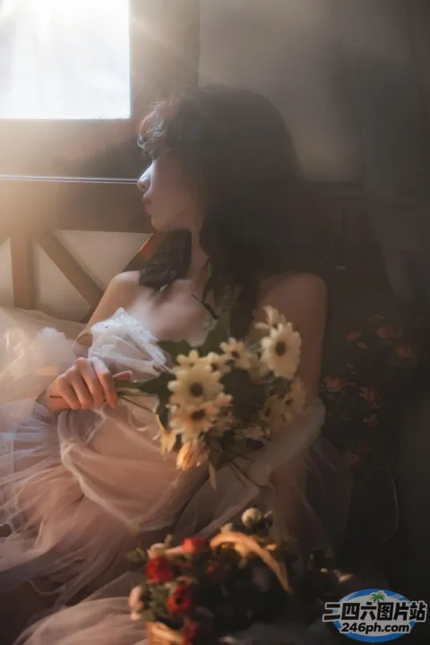 有一个女人坐在床上，手里拿着一束花