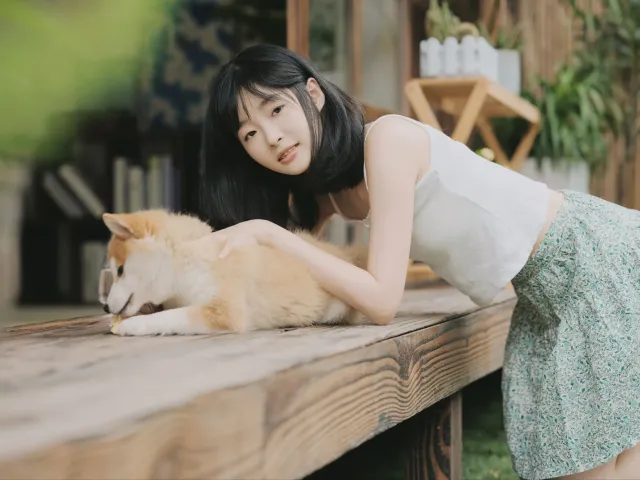 桌上有个女人在抚摸狗