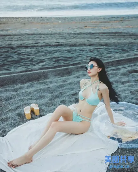 穿着比基尼坐在海滩上毛巾的 araffe 女人