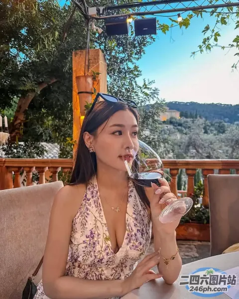 坐在桌子旁喝着一杯葡萄酒的女人