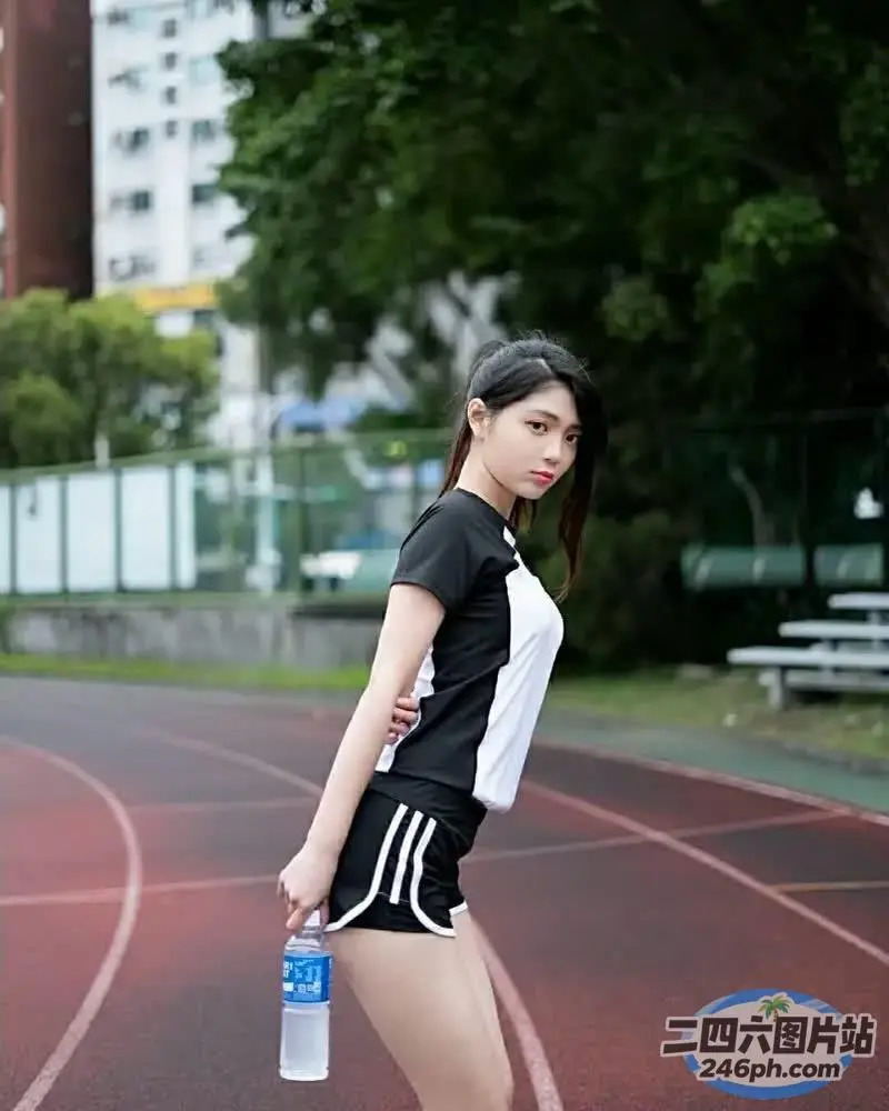身穿黑白衬衫和短裤的 Arafed 亚洲女子拿着水瓶