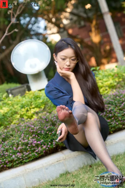 女人坐在地上，双腿交叉，手放在下巴上