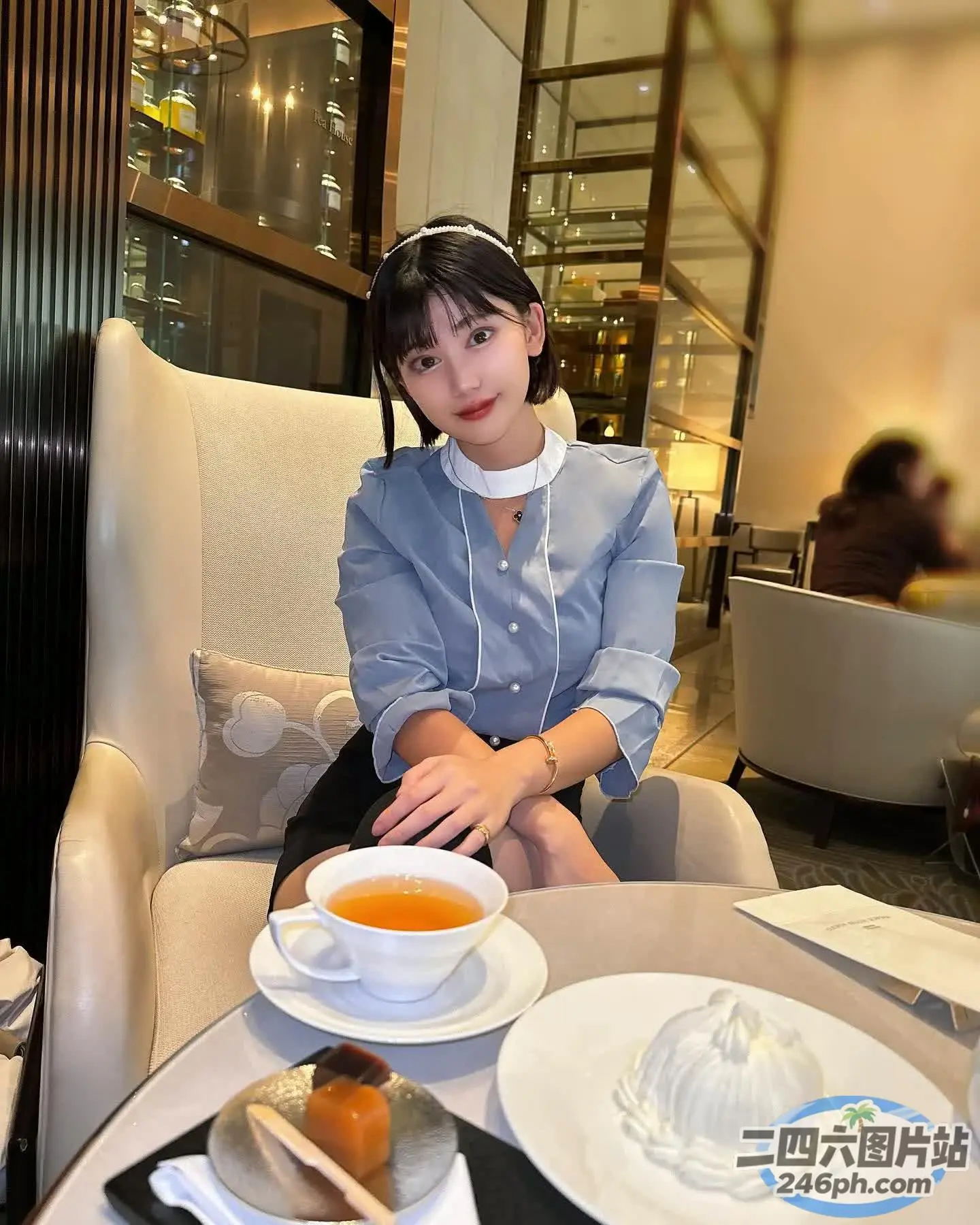 有个女人坐在一张桌子旁，桌上放着一盘食物