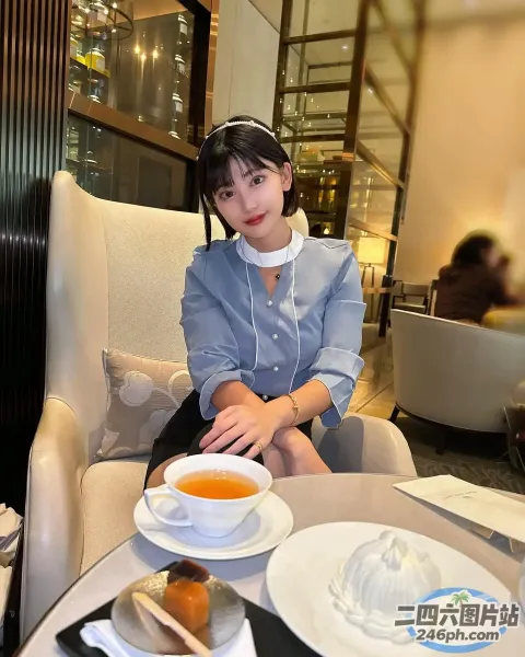 有个女人坐在一张桌子旁，桌上放着一盘食物