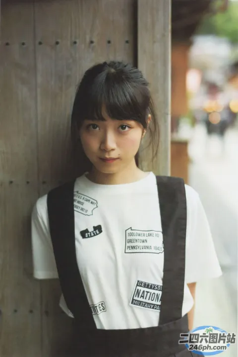 阿拉夫德亚裔女子靠在木墙上，穿着白衬衫