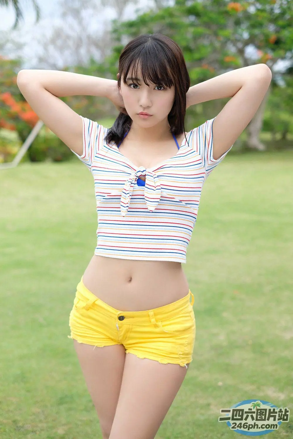 一名身穿黄色短裤的女子在公园里合影留念