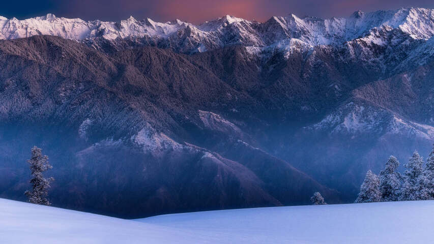 白雪皑皑的群山，一个人独自一人踩着滑雪板