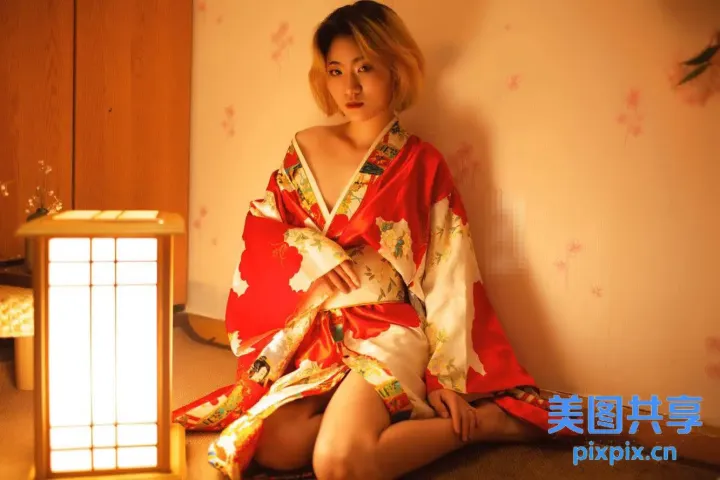 穿着和服的 arafed 女人坐在一盏灯的床上