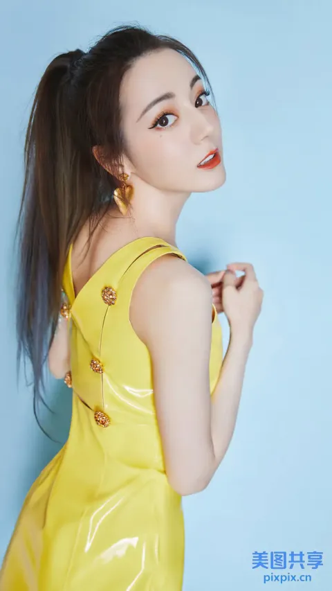一名身穿黄色连衣裙的女子摆姿势拍照的特写