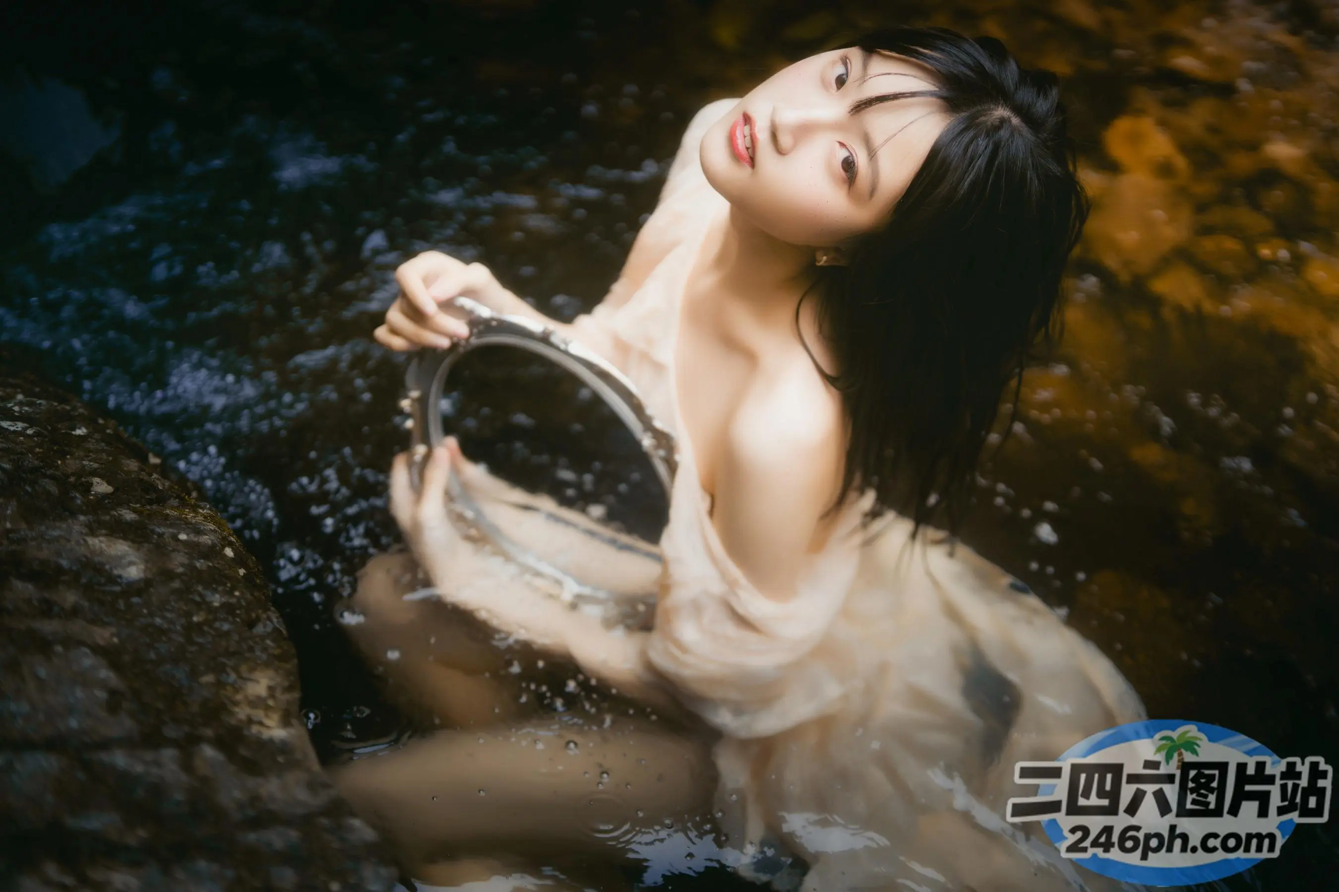 身穿白色连衣裙的阿拉夫德女子，手里拿着水桶坐在溪流中