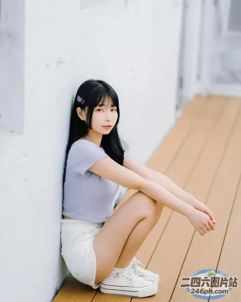 一个女人坐在靠墙的木地板上