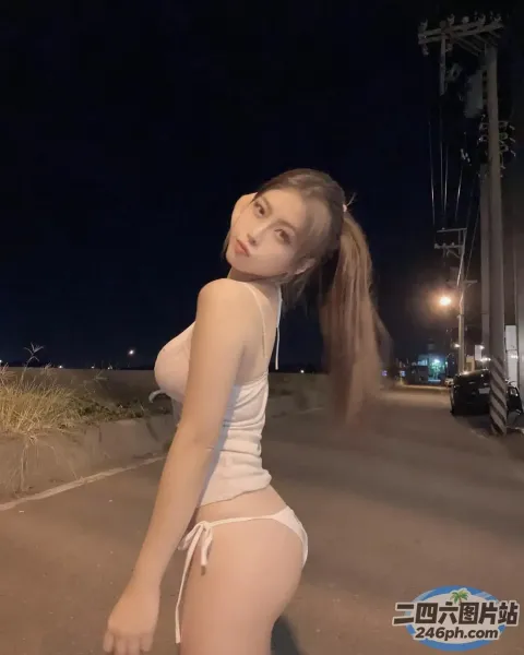 一个穿着白色比基尼的女人站在街上的特写