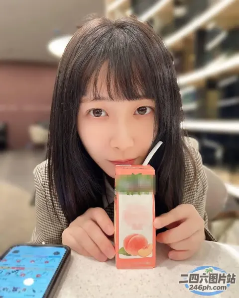 有一个女孩拿着饮料和手机