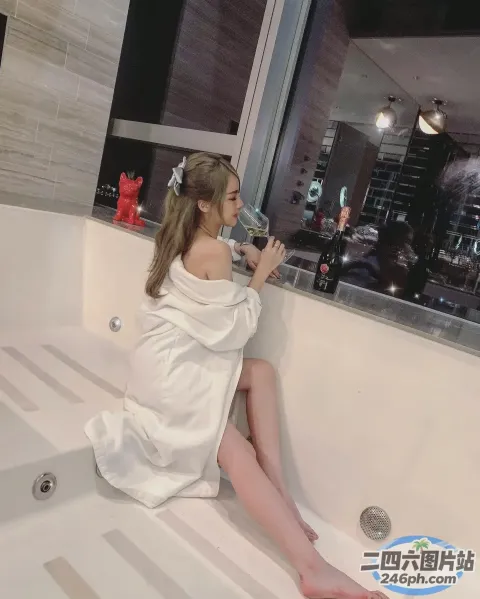 有个女人坐在浴缸里，手里拿着一杯水