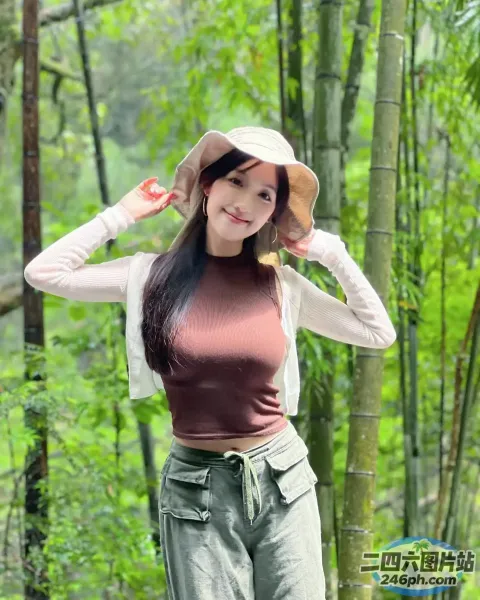 戴帽子和裤子的 Araffe 女人在竹林中摆姿势