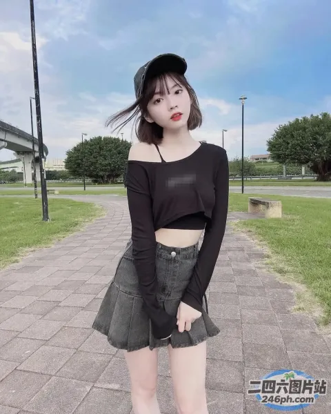 一名身穿黑色上衣和裙子的女子站在人行道上