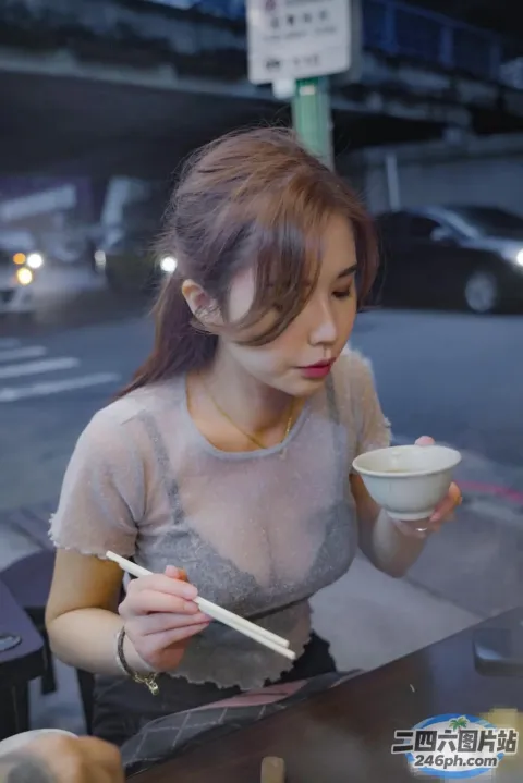 女人在桌子上用筷子吃一碗汤