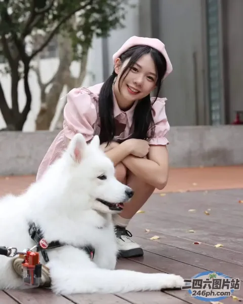有个女人跪在木地板上的一只白狗旁边