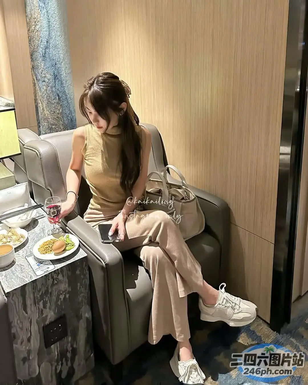 女人坐在椅子上，手里拿着一盘食物和饮料