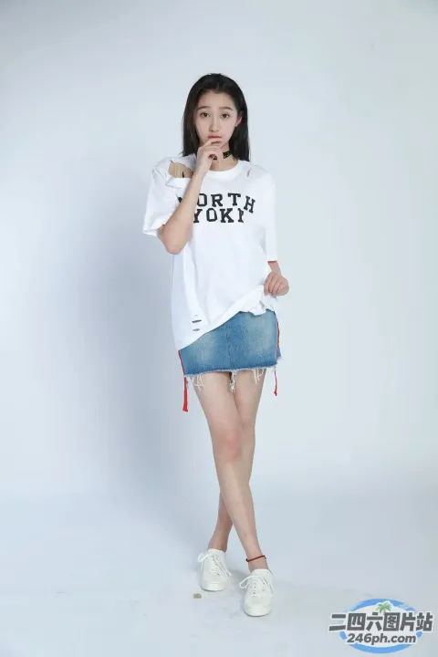 身穿白衬衫和牛仔裙的阿拉夫女子摆姿势拍照