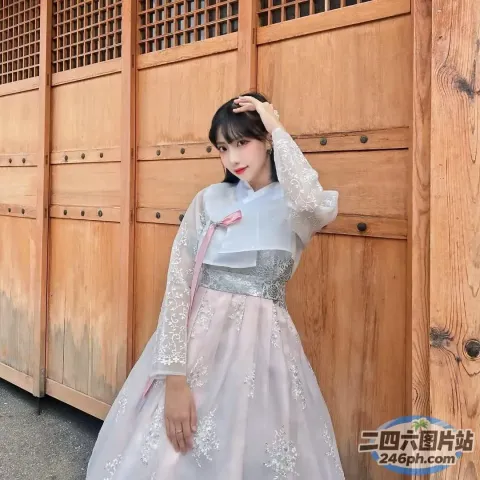 身穿白色连衣裙的 Araffe 女子靠在木墙上