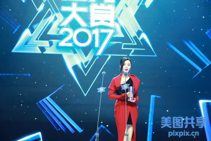 舞台上站着一个女人，拿着麦克风