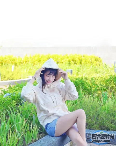 阿拉菲坐在长凳上，双腿交叉，戴着帽子