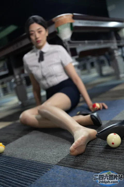 地板上坐着一个女人，手里拿着乒乓球拍