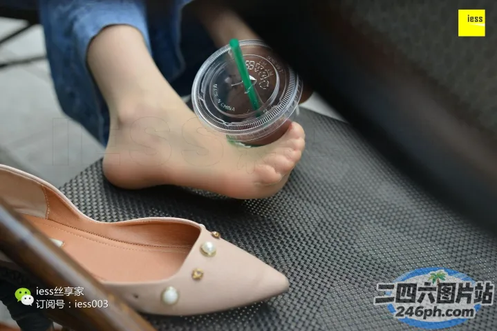 有人坐在椅子上，手里拿着一杯咖啡和一双鞋