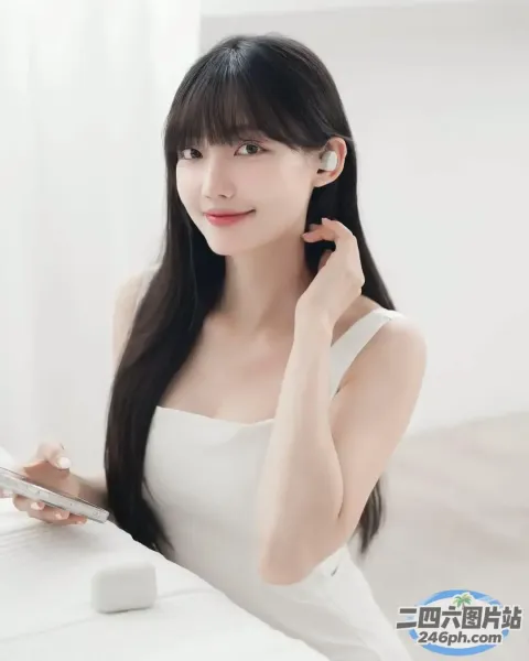 一位黑发长发的女士坐在桌旁，桌前放着一台笔记本电脑