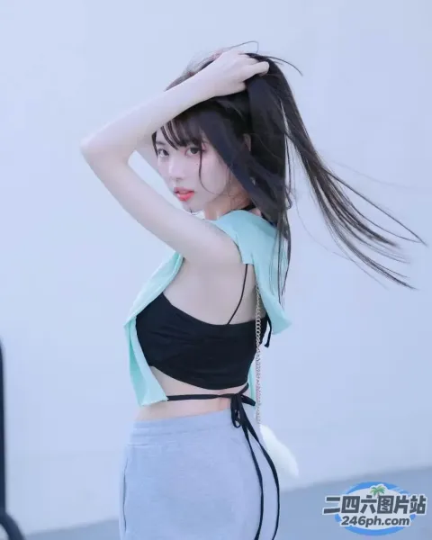 一名身穿黑色上衣和灰色裙子的女子摆姿势拍照